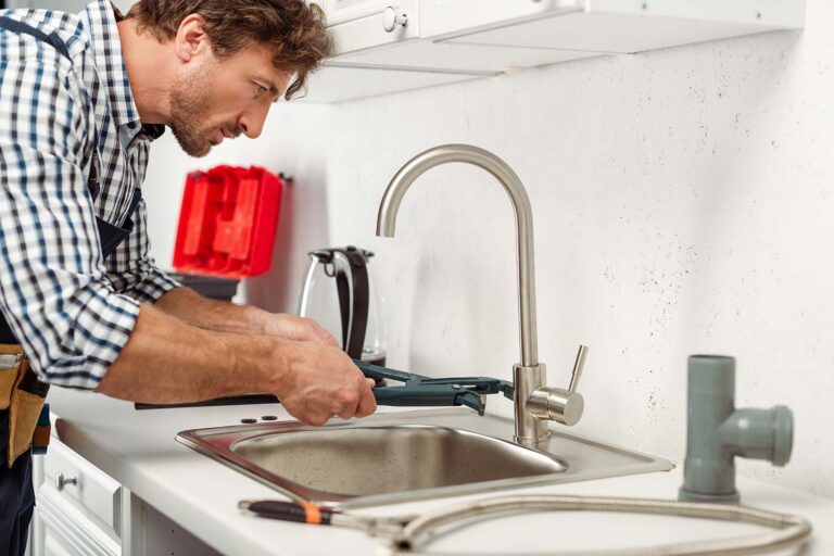 side-view-of-handsome-repairman-using-pipe-wrench-resize